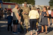 Military person speaking to people outside.
