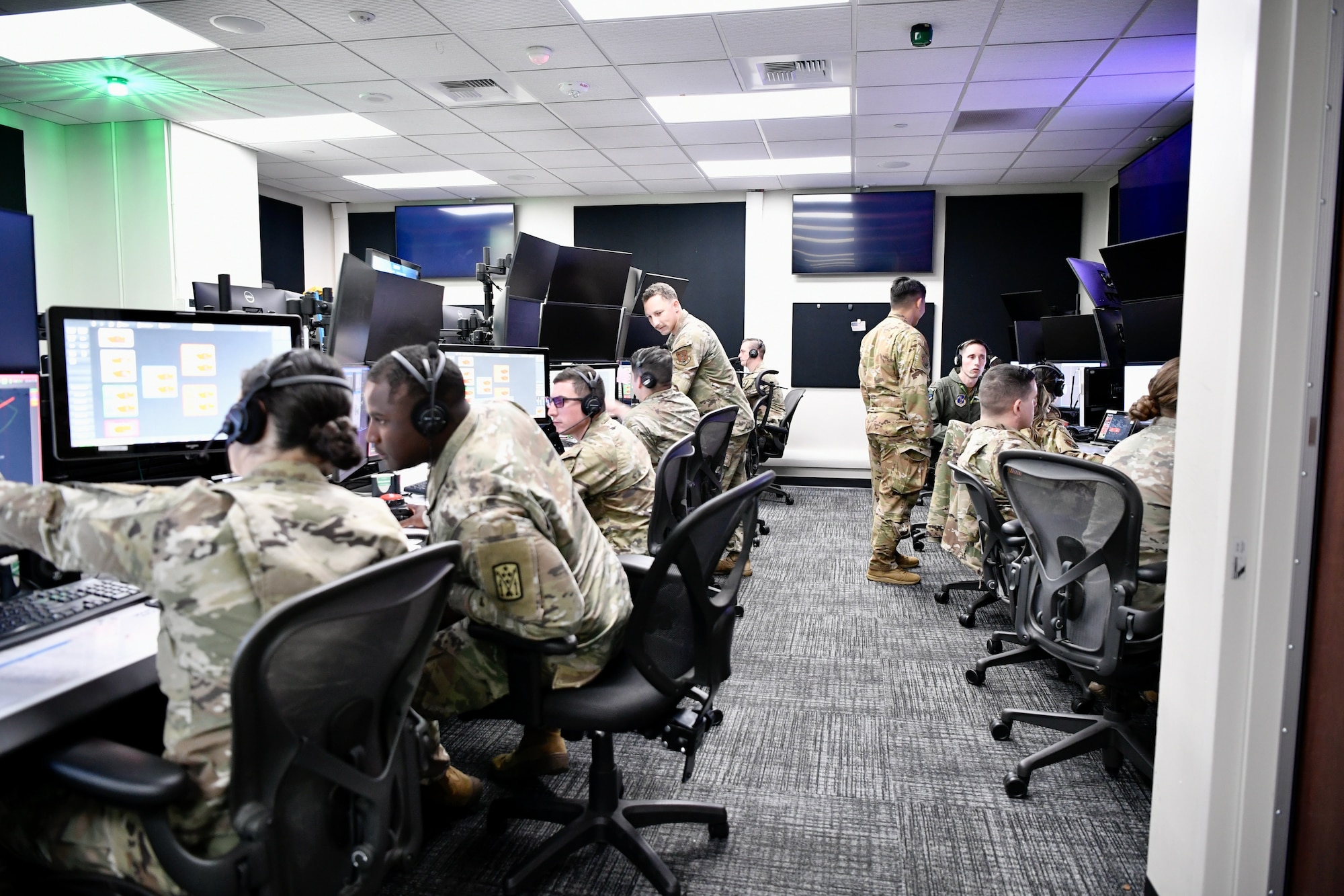 Soldiers and Airmen looking at computer monitor