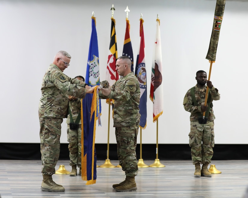 The command team of the 1108th Theater Aviation Sustainment Maintenance Group prepare to case their home unit colors to mark the official end of their tour in theater during a transfer of authority ceremony in the U.S. Central Command area of responsibility, Aug. 14, 2024.  (U.S. Army photo by Sgt. 1st Class Gecyca Martin)