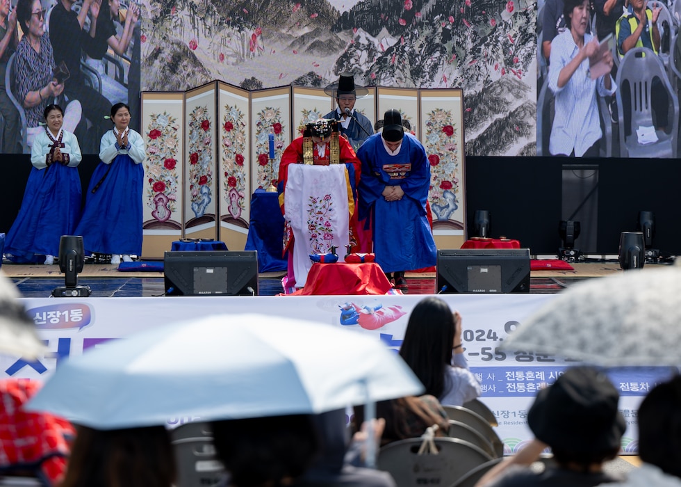 U.S. Air Force Senior Airman Gabriel Mercado, 51st Force Support Squadron member, participates with his wife in a traditional Korean wedding ceremony outside Osan Air Base, Republic of Korea, Sept. 28, 2024. During the festival, participants could take part in various activities designed to facilitate a mutual cultural exchange between the ROK and the U.S. (U.S. Air Force photo by Maj. Kippun Sumner)