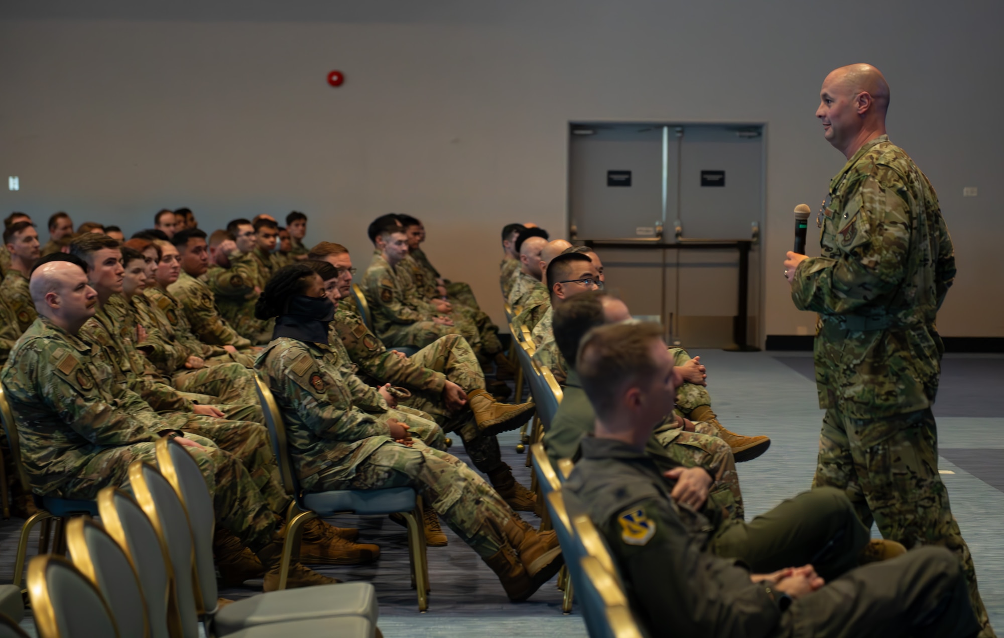 The 374th Airlift Wing commander walks around the room as he speaks to a crowd during the all-call event.