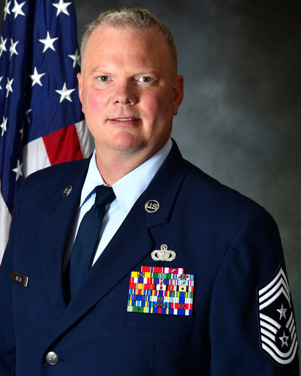 A man in his Air Force service dress takes his official photo.