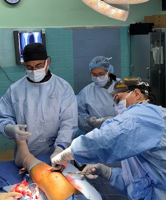 Cmdr. Louis Lewandowski (left front), an Expeditionary Medical Facility Kilo orthopedic trauma surgeon, works with Hospital Corpsman Second Class Brandon Cassidy (left back) and Honduran orthopedic residents to place a femoral external fixator on a trauma patient in the operating room at Hospital Escuela, Tegucigalpa, Honduras, Sep. 17, 2024. In collaboration with joint forces and the partner nation, EMF Kilo conducted its first orthopedic surgical mission alongside Hospital Escuela medical staff treating and performing surgical procedures on patients with oncologic or orthopedic traumatic injuries. (U.S. Navy photo by Lt. Cmdr. Sheree Blackwell)