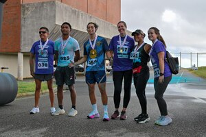 Photo of three male runners and three female runners posing after winning 1st, 2nd, or 3rd place in their perspective category. They do have colored powder on them as it was a color run.
