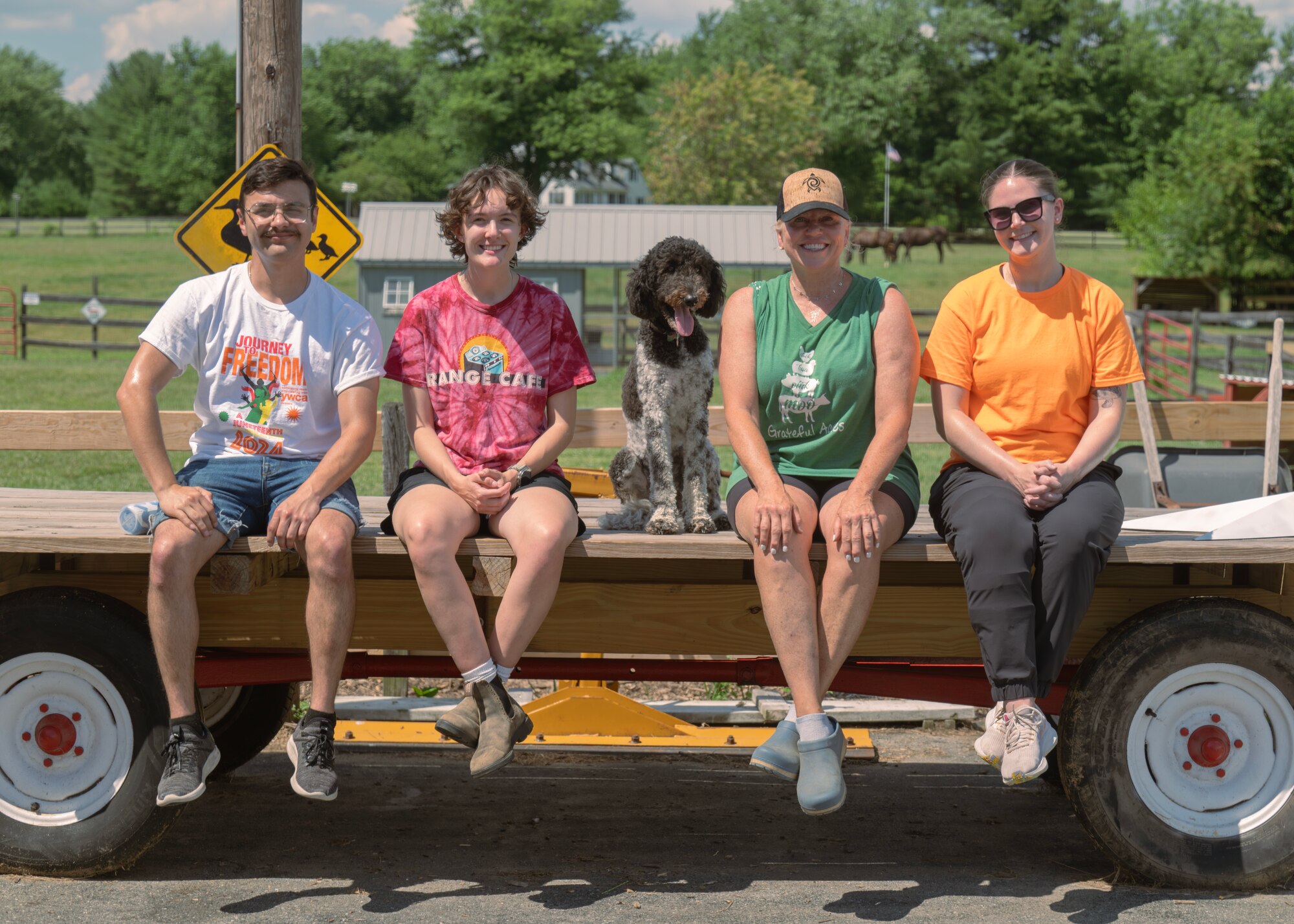 A group of people sit on a wagon.