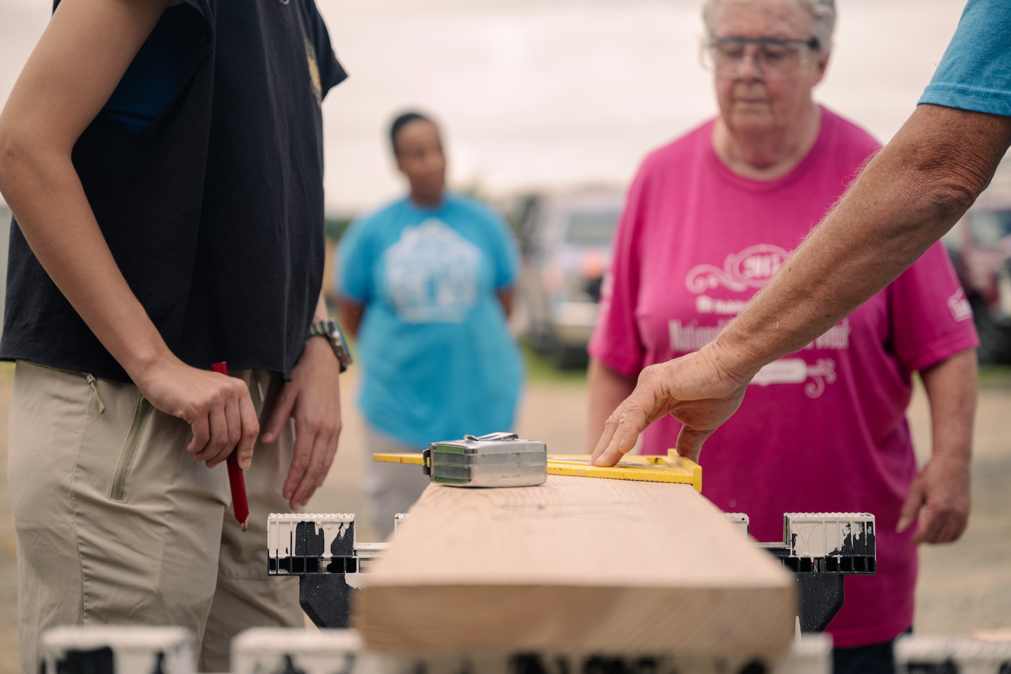Volunteers mark a piece of wood.