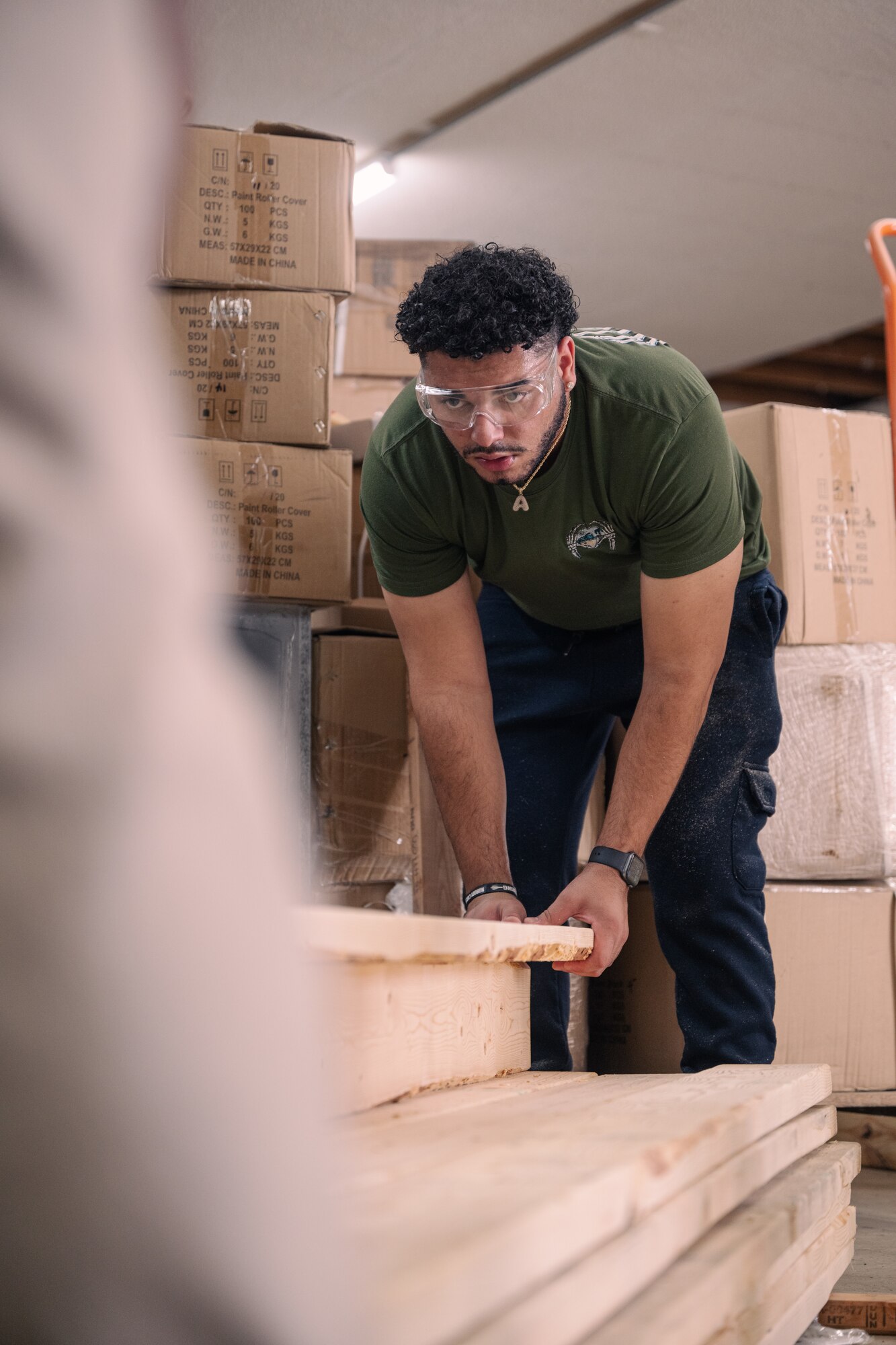 A man holds down a piece of wood