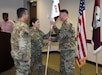 Capt. Shirly Rivera, incoming commander of U.S. Army Medical Logistics Command’s Headquarters and Headquarters Detachment, passes the unit guidon to her new detachment sergeant, Master Sgt. William Harbeson III, during an assumption of command and responsibility ceremony Sept. 30 at Fort Detrick, Maryland. Also pictured is AMLC Commander Col. Marc Welde, who presided over the ceremony.