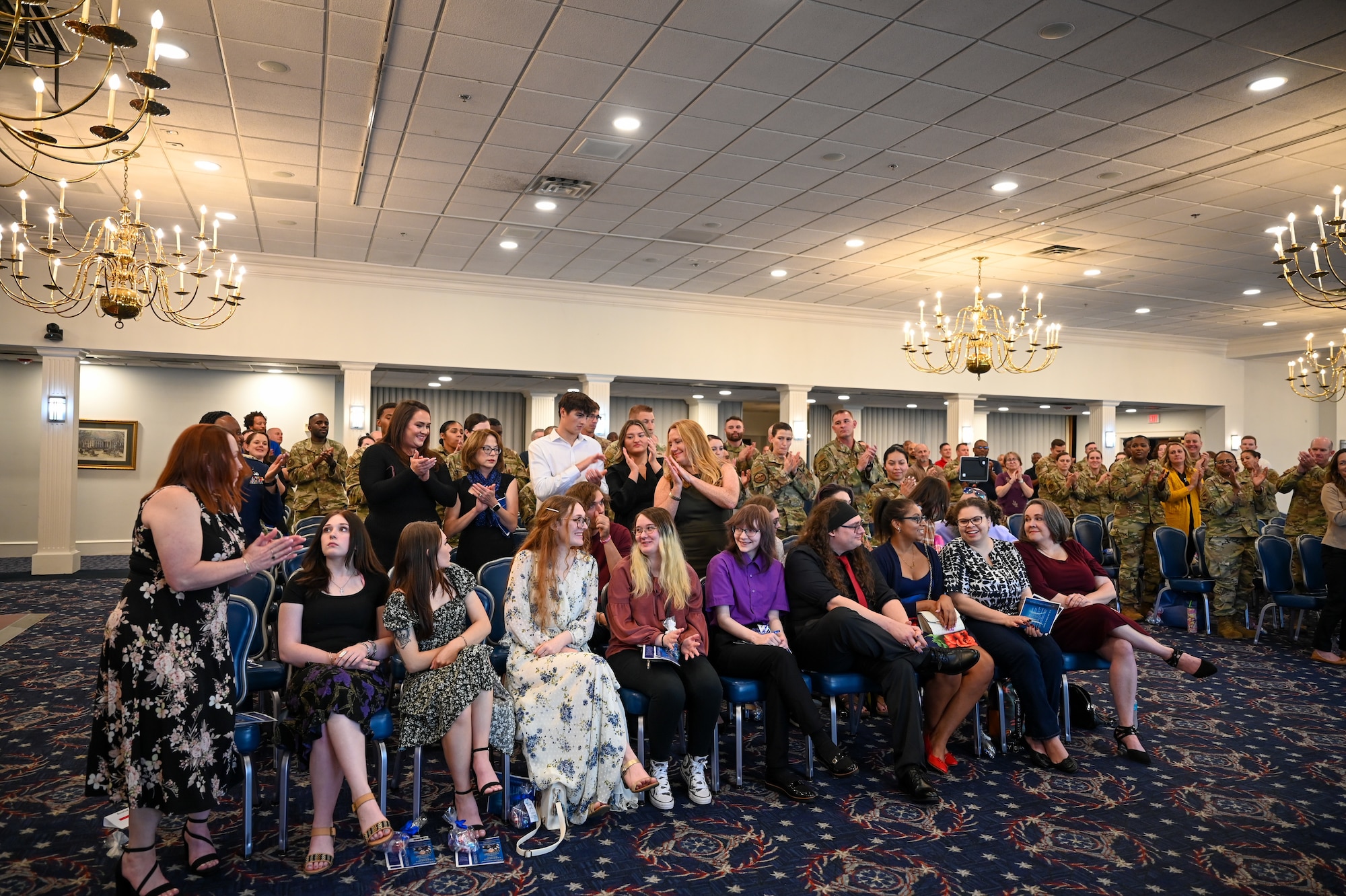 Family members of retiring U.S. Air Force Chief Master Sgt. Donald M. Cleveland, former senior enlisted leader for the 11th Mission Support Group at Joint Base Anacostia-Bolling, smile as guests recognize them for their support of Cleveland during his retirement ceremony at JBAB, Washington, D.C., Sept. 20, 2024. Several dozen family members, friends and colleagues gathered to celebrate Cleveland’s 29-year career in the Air Force. (U.S. Air Force photo by Airman 1st Class Shanel Toussaint)