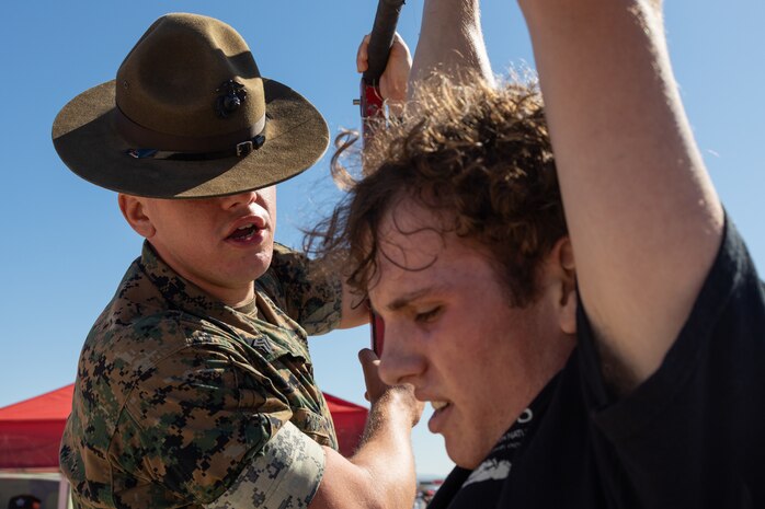 U.S. Marine Corps Sgt. Michael Pocrnich, a drill instructor with Delta Company, 1st Battalion, Marine Corps Recruit Depot San Diego, encourages an expo attendee participating in a pull-up challenge during the 2024 Marine Corps Air Station Miramar Airshow at MCAS Miramar in San Diego, Sept. 29, 2024. The MCAS Miramar Airshow provides a unique flightline experience with static displays and daytime shows that feature military demonstration teams, civilian acrobatic teams, aerial solo acts, vintage aircraft and warbirds. (U.S. Marine Corps photo by Cpl. Bruin Largent)