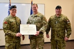From left, Maj. Gen. John Errington, commander of the Canadian Army Doctrine and Training Centre; U.S. Air Force Lt. Col. Kevin Thomas, commander of the 284th Air Support Operations Squadron; and Chief Warrant Officer Pascal Gagne, Sergeant Major of the Canadian Army Doctrine and Training Centre, hold the scroll element of the Canadian Forces Unit Commendation award during a ceremony at Smoky Hill Air National Guard Range, Kansas, Oct. 1, 2024.
