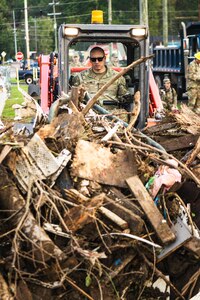 U.S. Air National Guard Master Sgt. Matthew Finfrock, Operations Superintendent with the 134th Civil Engineer Squadron, assists with debris clearing near a supplies distribution location in Johnson City, Tenn., Oct. 2, 2024.