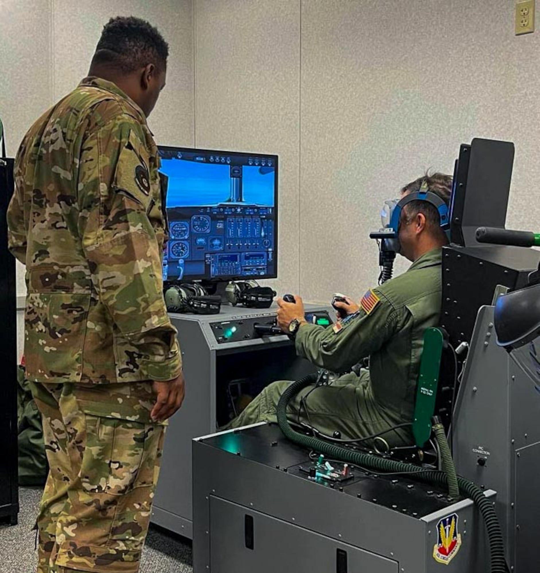 TSgt Kinyada Johnson, aerospace physiology training flight chief, instructs a student on using a reduced oxygen breathing device in a simulated flying environment. This training helps members recognize and respond o the effects of hypoxia, ensuring they remain alert and mission-ready at high altitudes.