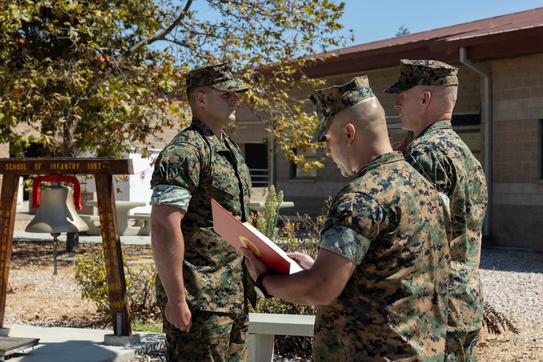 U.S. Marine Corps Sgt. Maj. Damian Rodriguez, center, sergeant major of School of Infantry West, and Col. Patrick Byrne, right, commanding officer of SOI-West, present the Navy and Marine Corps Medal to Staff Sgt. Brett Meil, left, a Marine combat instructor with Training Company, Infantry Training Battalion, SOI-West, during an award ceremony at Marine Corps Base Camp Pendleton, California, Sept. 24, 2024. During the ceremony, Meil was presented with the Navy and Marine Corps Medal, the highest non-combat decoration that can be awarded for heroism, for his actions on June 13, 2023, where he saved a student’s life and took shrapnel in the process. (U.S. Marine Corps photo by Cpl. Sydni Jessee)