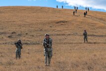 Airmen running down a hill.