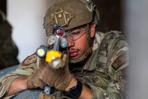 An Airman pointing a gun toward the camera.