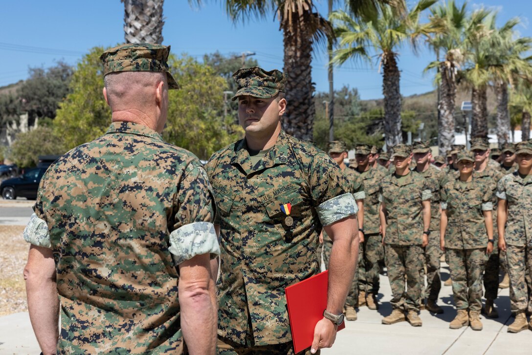 U.S. Marine Corps Col. Patrick Byrne, left, commanding officer of School of Infantry West, presents the Navy and Marine Corps Medal to Staff Sgt. Brett Meil, right, a Marine combat instructor with Training Company, Infantry Training Battalion, SOI-West, during an award ceremony at Marine Corps Base Camp Pendleton, California, Sept. 24, 2024. During the ceremony, Meil was presented with the Navy and Marine Corps Medal, the highest non-combat decoration that can be awarded for heroism, for his actions on June 13, 2023, where he saved a student’s life and took shrapnel in the process. (U.S. Marine Corps photo by Cpl. Sydni Jessee)