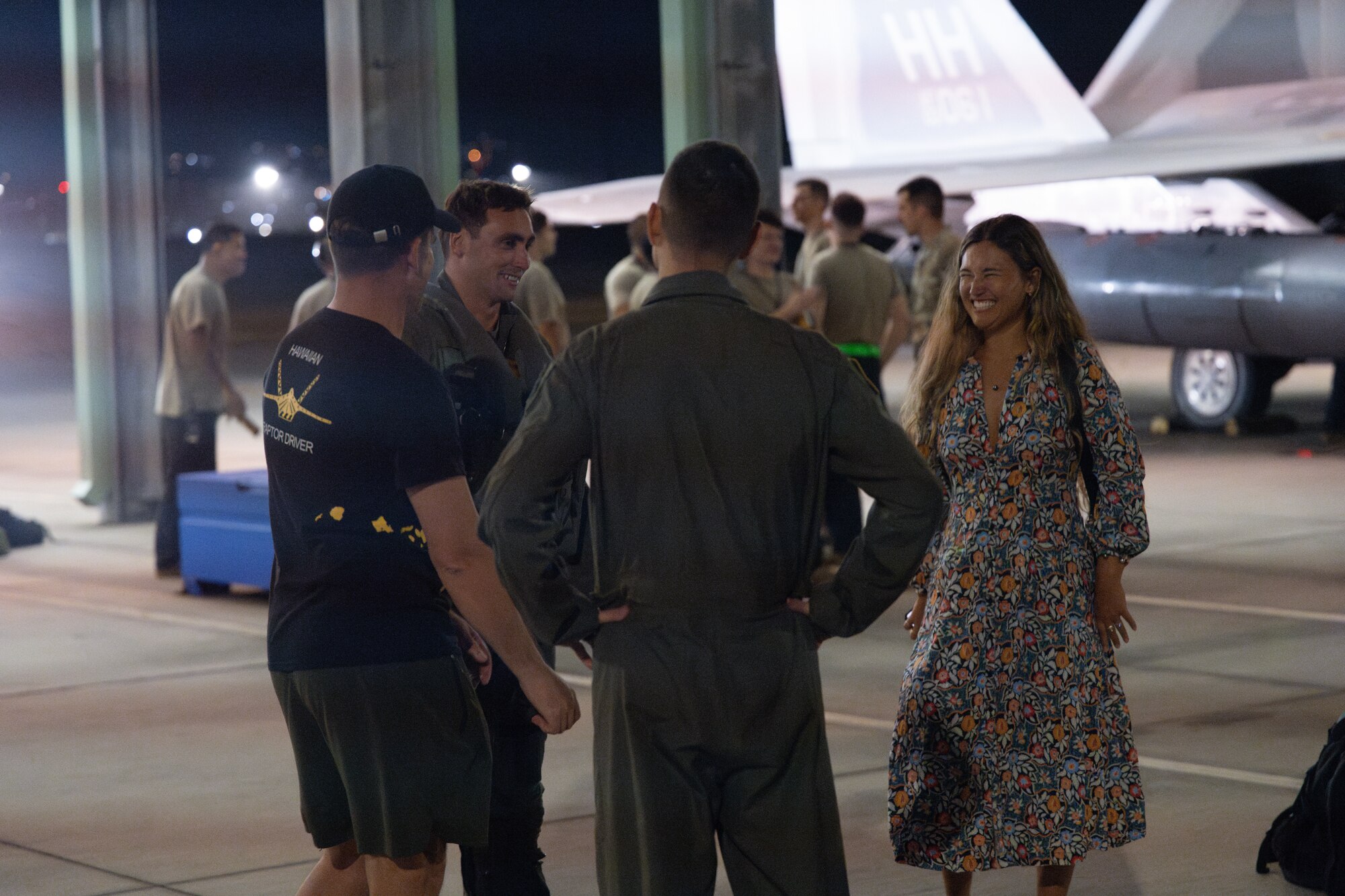 Airmen and families greet deployers at night after returning home.
