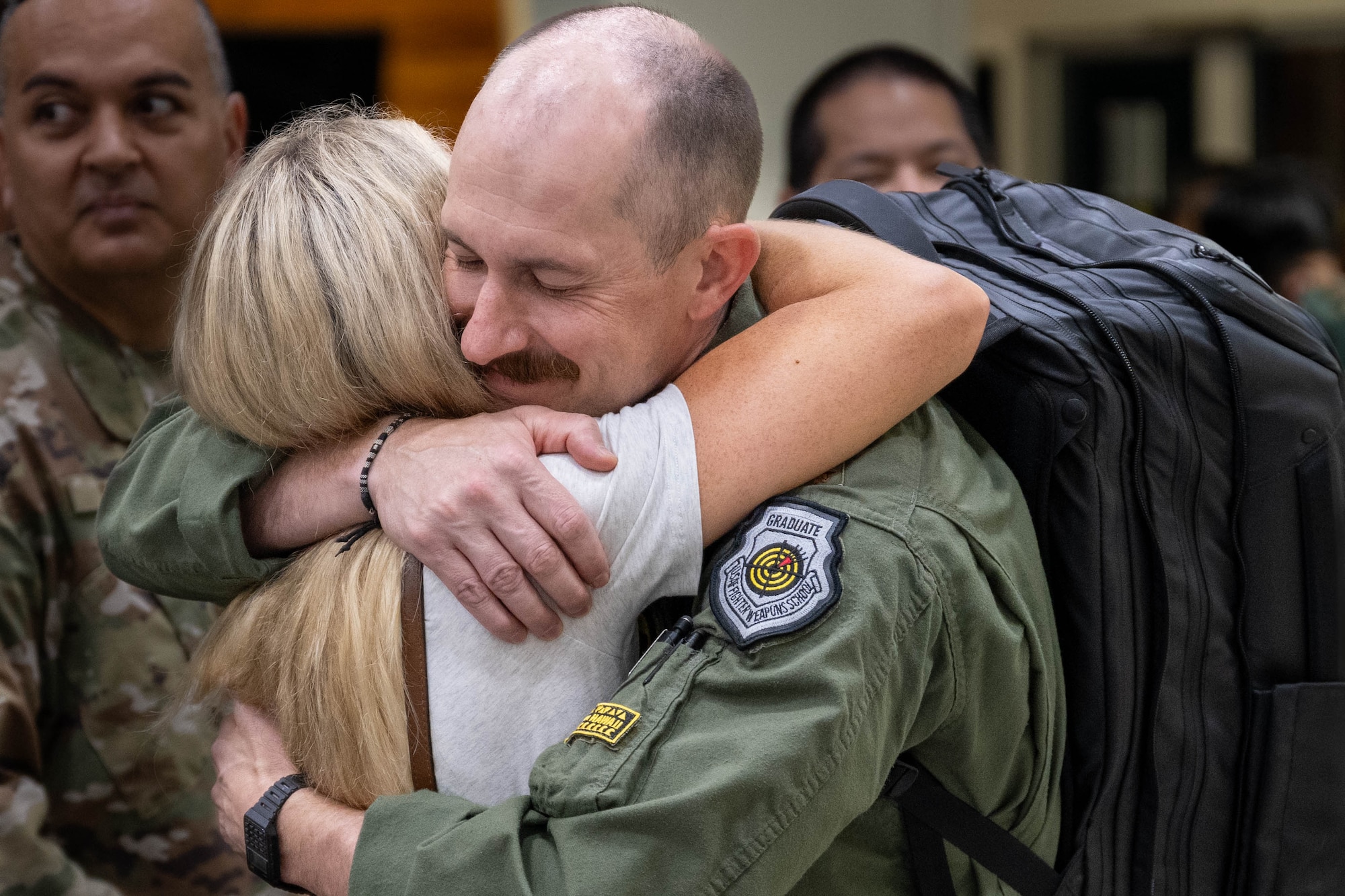 A U.S. Air Force Airmen returning from deployment hugs a loved one.