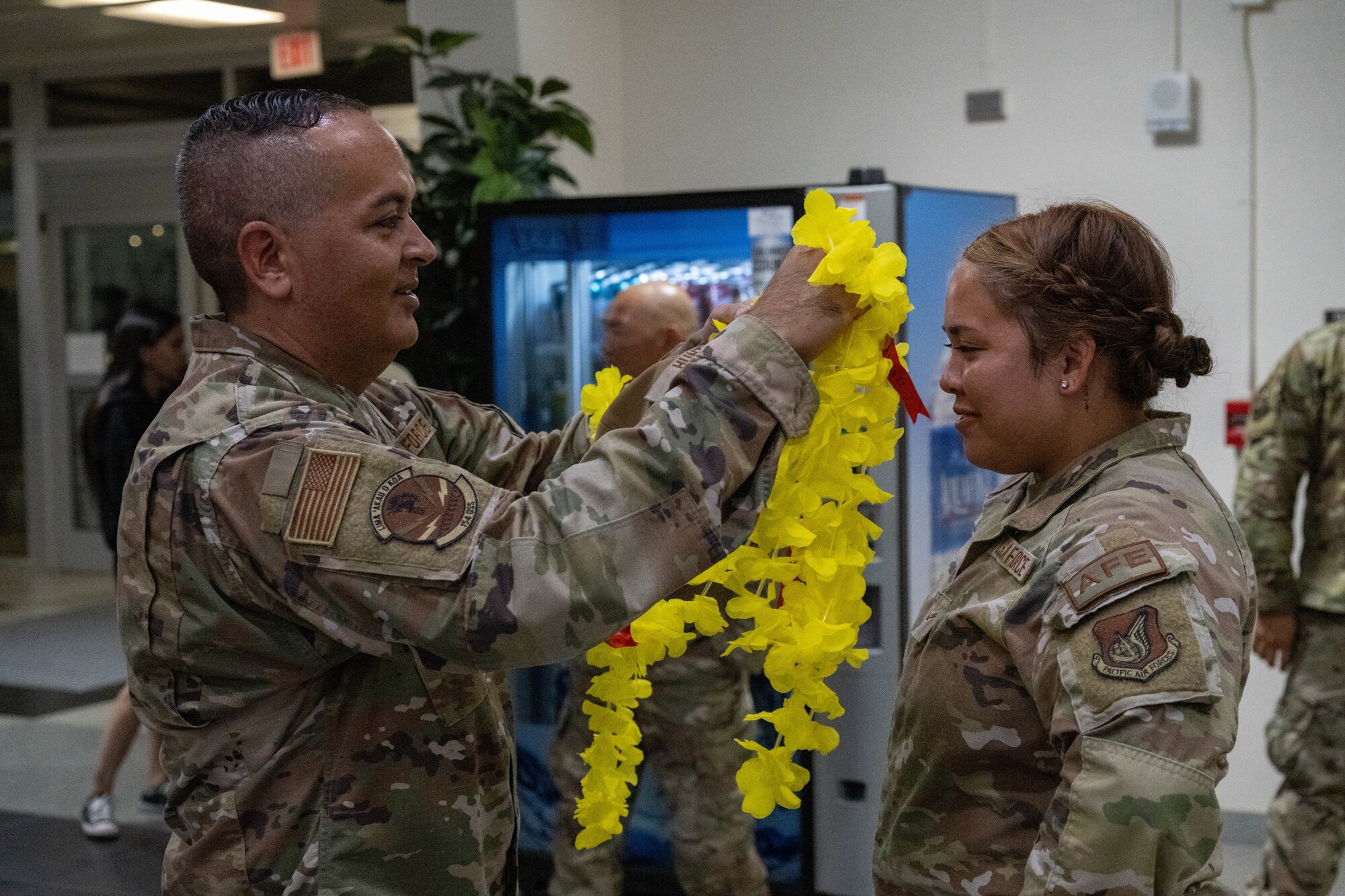 A U.S. Air Force Airman is welcomed back from with a Hawaiian flower necklace known as a lei.