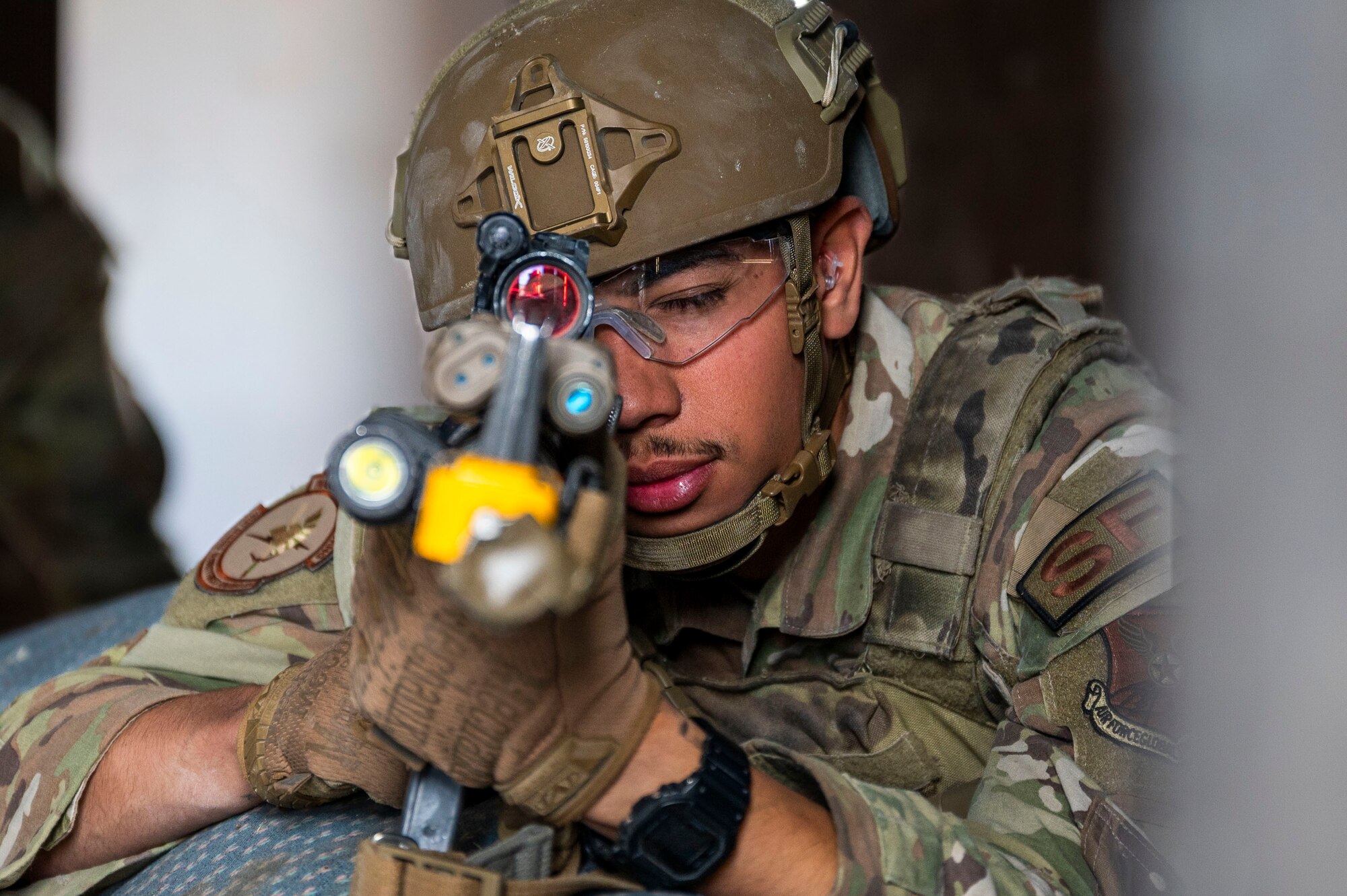 An Airman pointing a gun toward the camera.