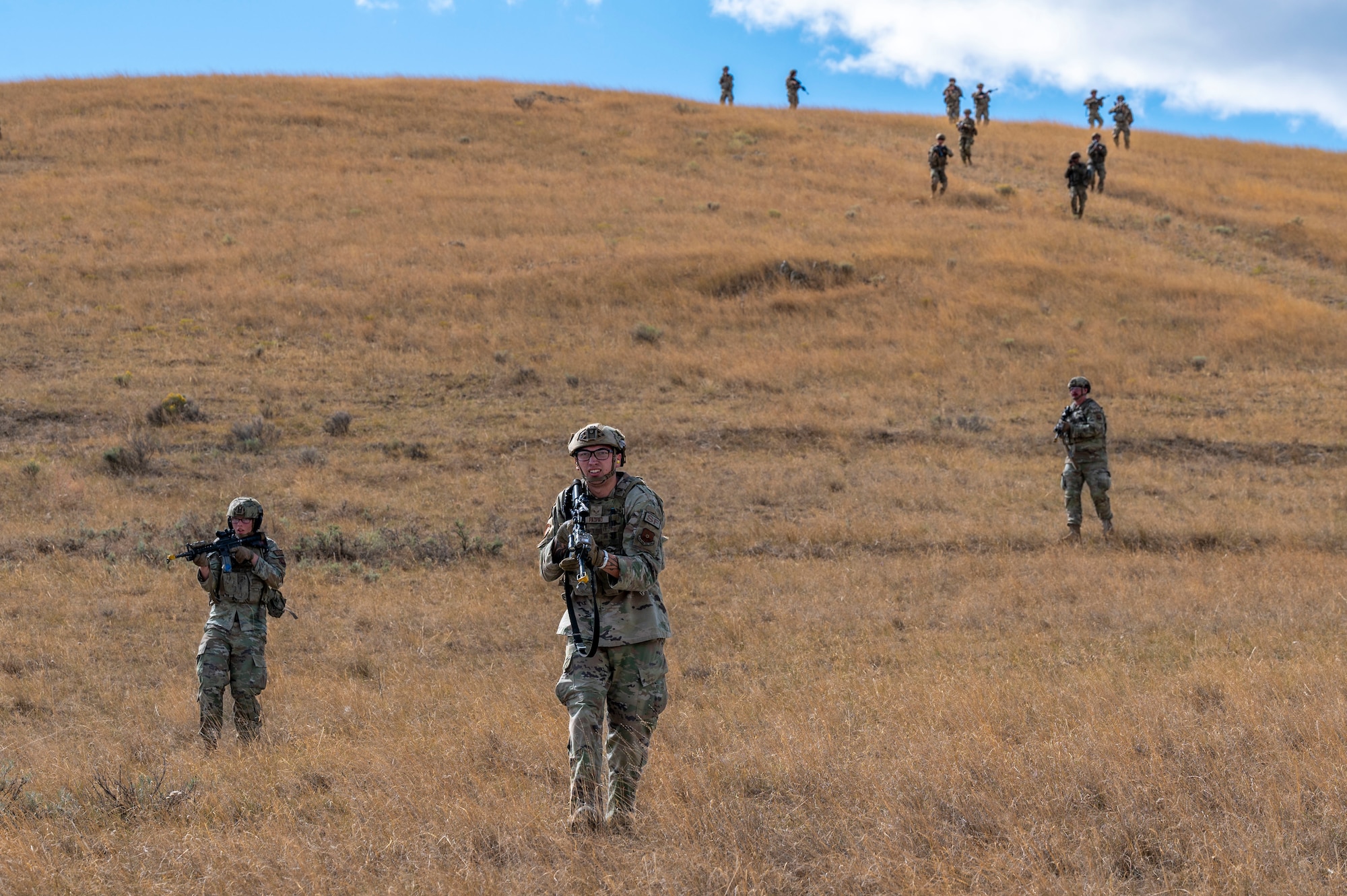 Airmen running down a hill.