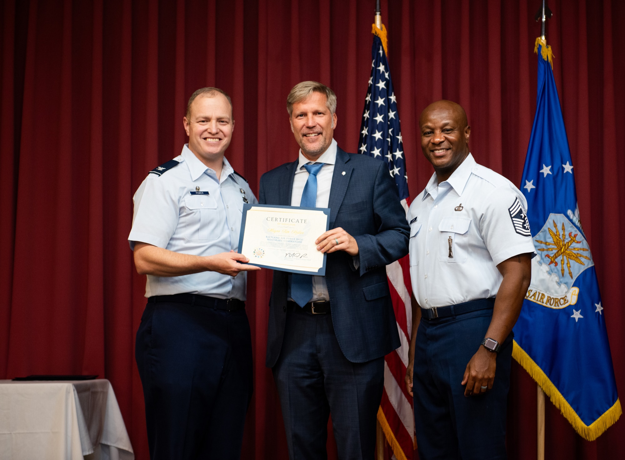 man receiving certificate poses for a photo on stage