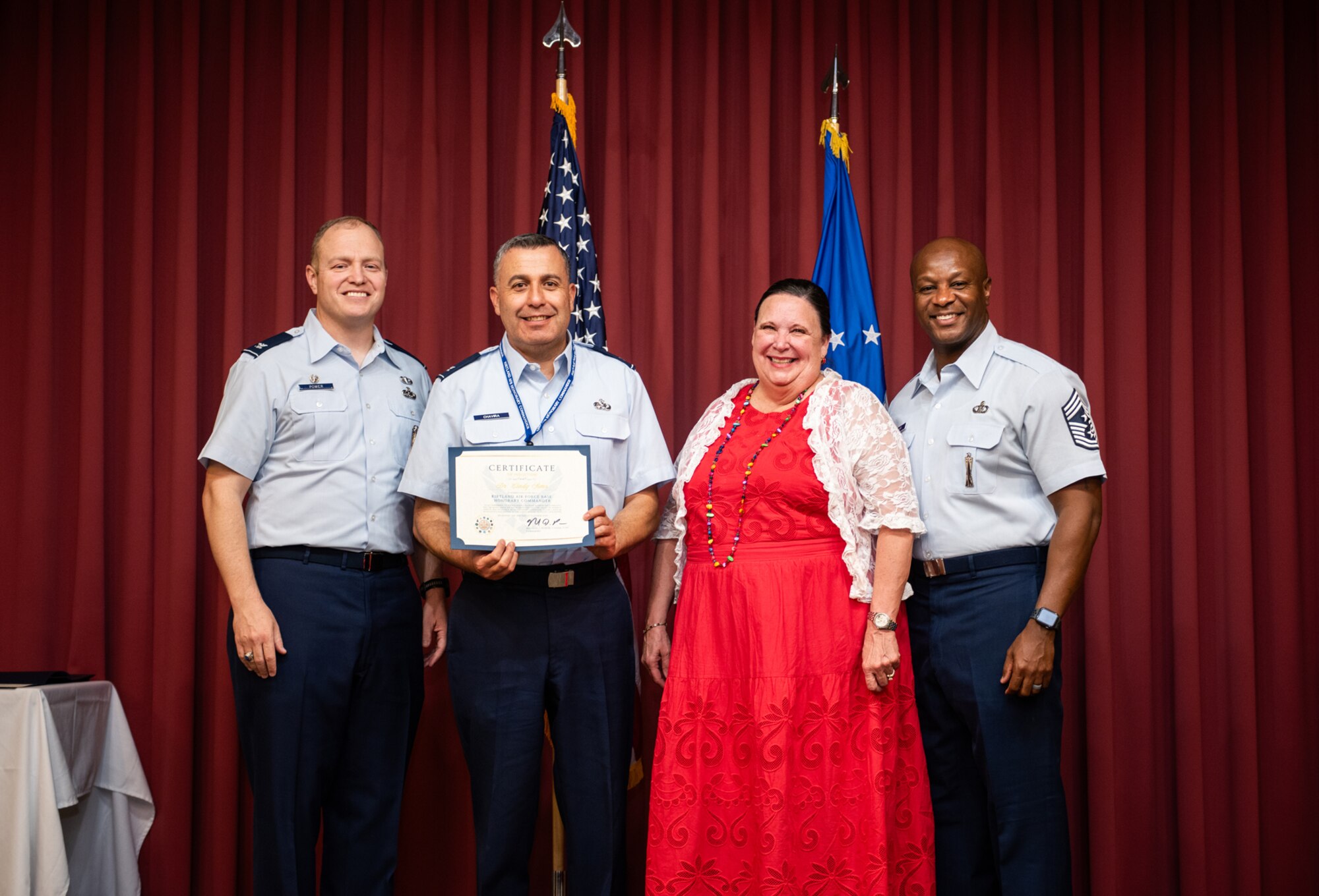 People on stage receiving certificate posing for a photo