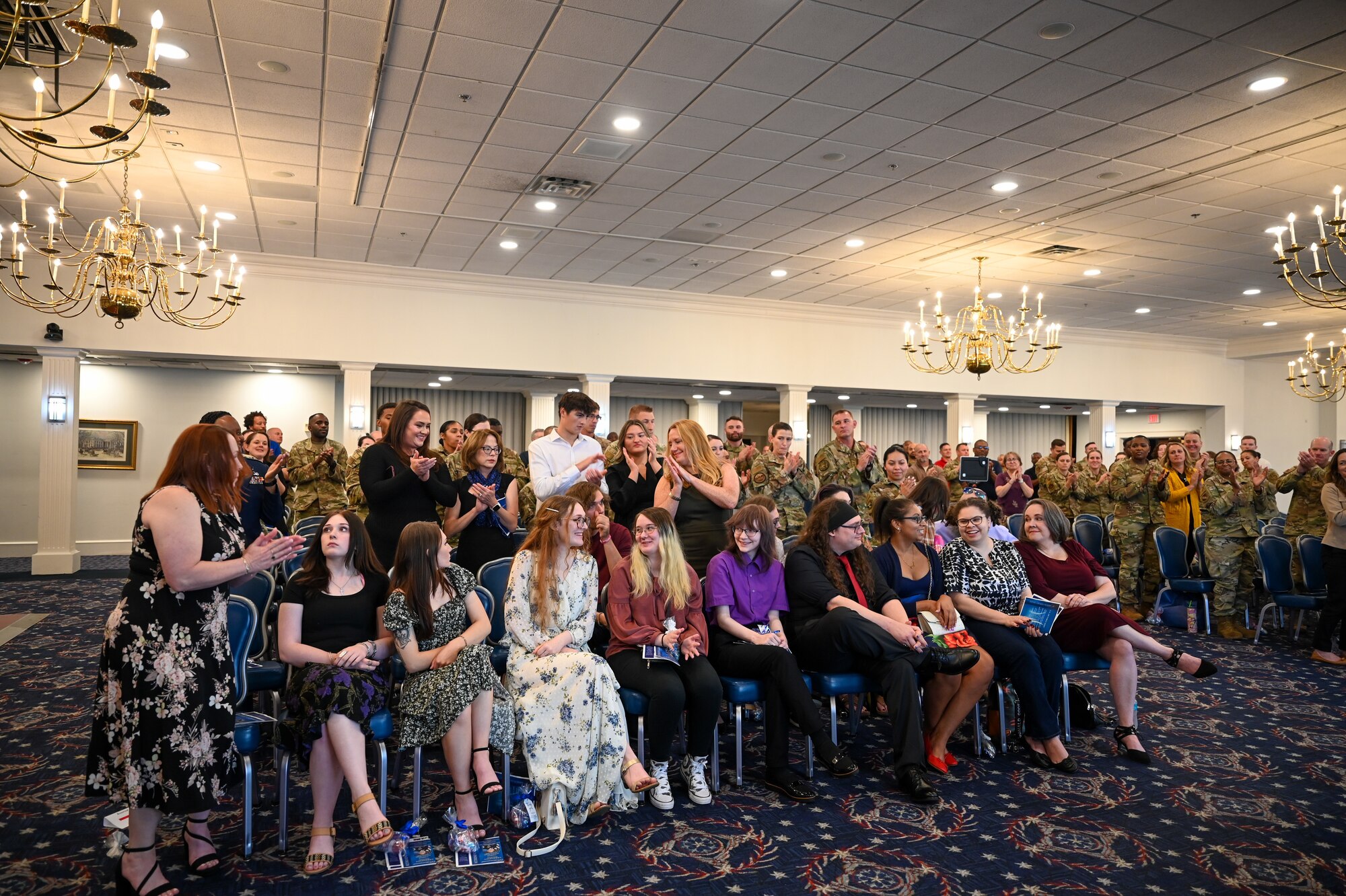 Family members of retiring U.S. Air Force Chief Master Sgt. Donald M. Cleveland, former senior enlisted leader for the 11th Mission Support Group at Joint Base Anacostia-Bolling, smile as guests recognize them for their support of Cleveland during his retirement ceremony at JBAB, Washington, D.C., Sept. 20, 2024. Several dozen family members, friends and colleagues gathered to celebrate Cleveland’s 29-year career in the Air Force. (U.S. Air Force photo by Airman 1st Class Shanel Toussaint)