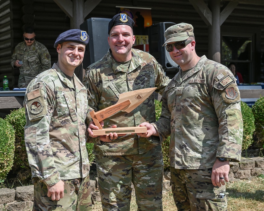 Chief Master Sgt. Gordon M.R. Wager, center, 445th AW command chief, presents Senior Airmen Austin Dilday, left, and Senior Airman Garett Mize, 445th Security Forces Squadron fire team members, with the Command Chief Challenge award.