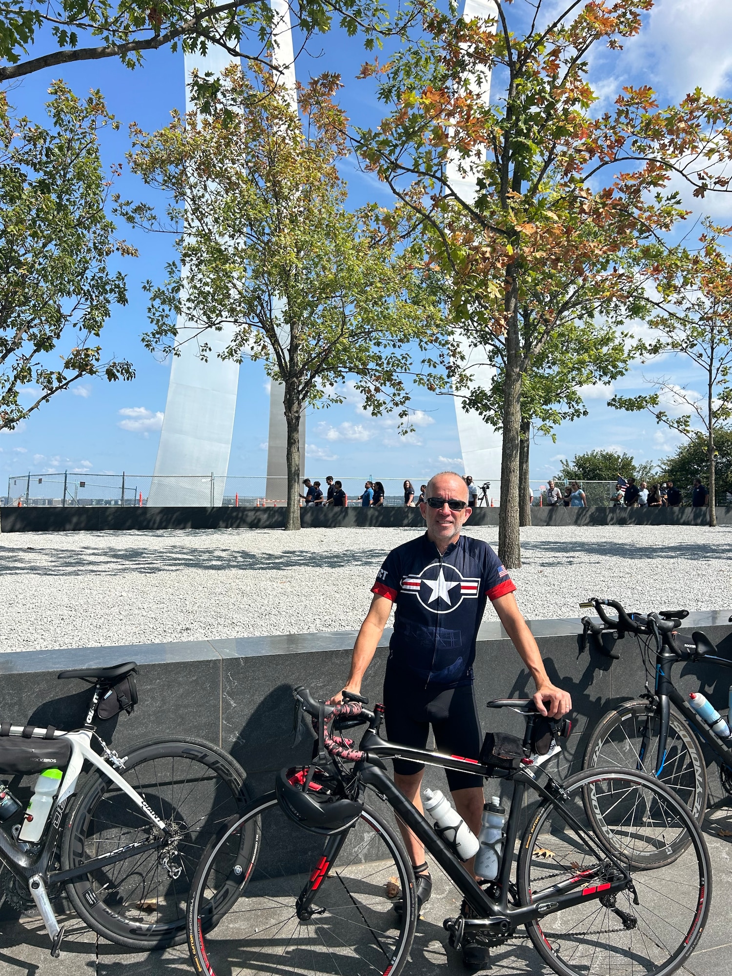 An individual stands with his bicycle.