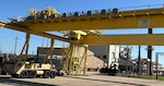 military vehicles and an overhead gantry crane