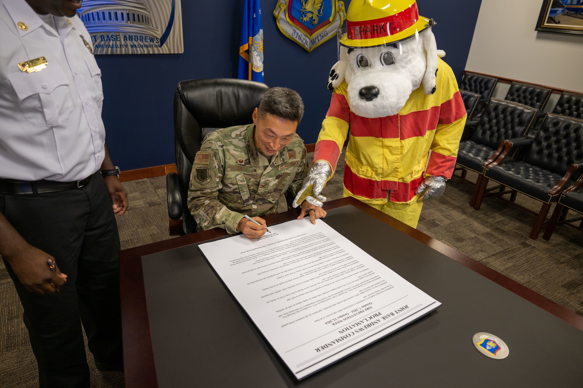 Mascot points at sign for a man to sign