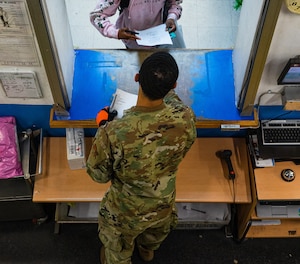 U.S. Air Force Airman 1st Class Damon Thompson, 51st Force Support Squadron postal clerk, speaks with a customer collecting an oversized package at the Osan Air Base Post Office, South Korea, Dec. 9, 2020. Thompson commits an additional three or four hours to his normal nine-hour postal shift during the holiday season to serve a constant flow of customers. (U.S. Air Force photo by 1st Lt. Daniel de La Fé)