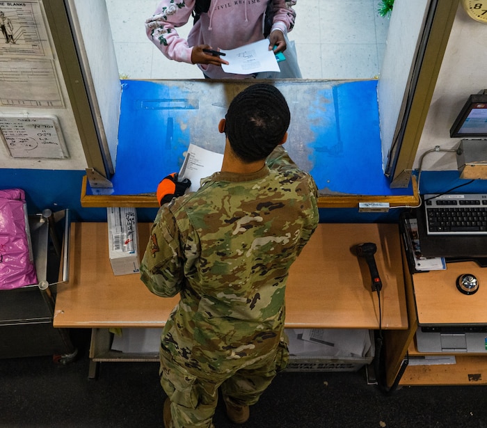 U.S. Air Force Airman 1st Class Damon Thompson, 51st Force Support Squadron postal clerk, speaks with a customer collecting an oversized package at the Osan Air Base Post Office, South Korea, Dec. 9, 2020. Thompson commits an additional three or four hours to his normal nine-hour postal shift during the holiday season to serve a constant flow of customers. (U.S. Air Force photo by 1st Lt. Daniel de La Fé)