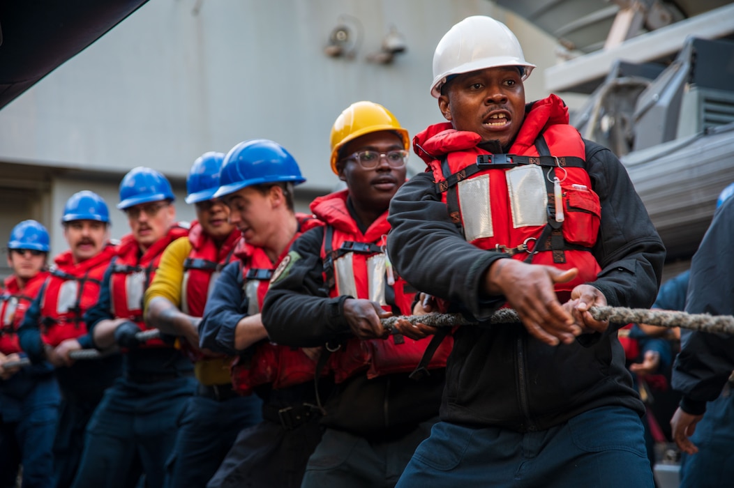 Sailors aboard USS New York (LPD 21) heave a line during a replenishment in the Mediterranean Sea.