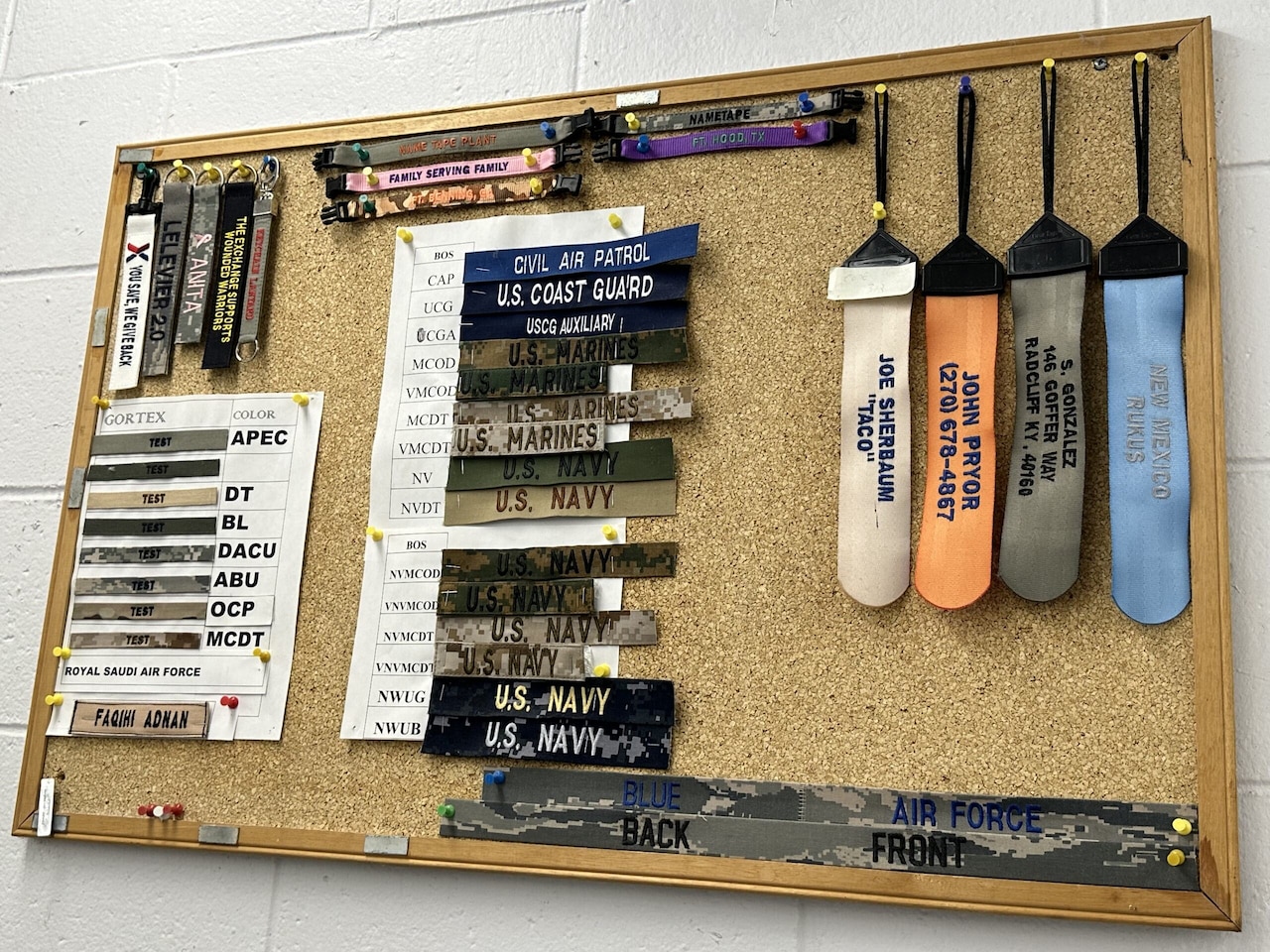 A cork bulletin board showcases several types of fabric name tapes, key chains and bracelets.