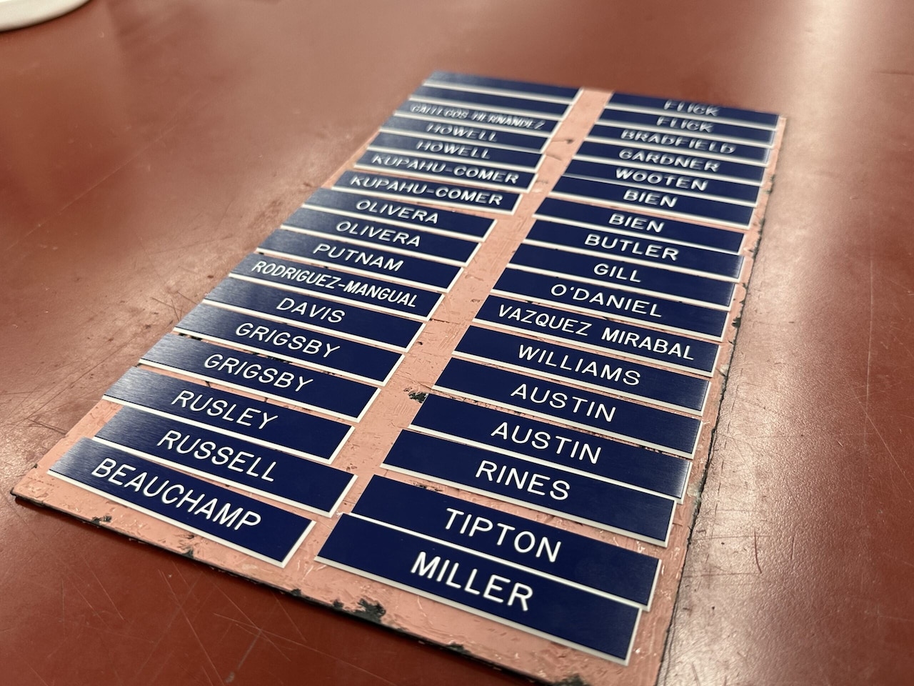 Several plastic name tags sit in two columns on a desk.