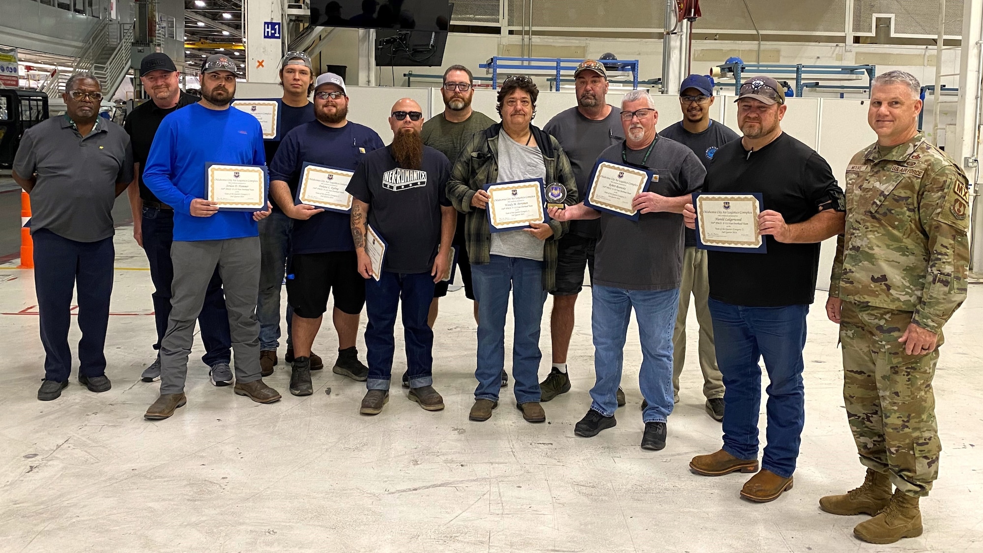 A group of 13 men holding certificates