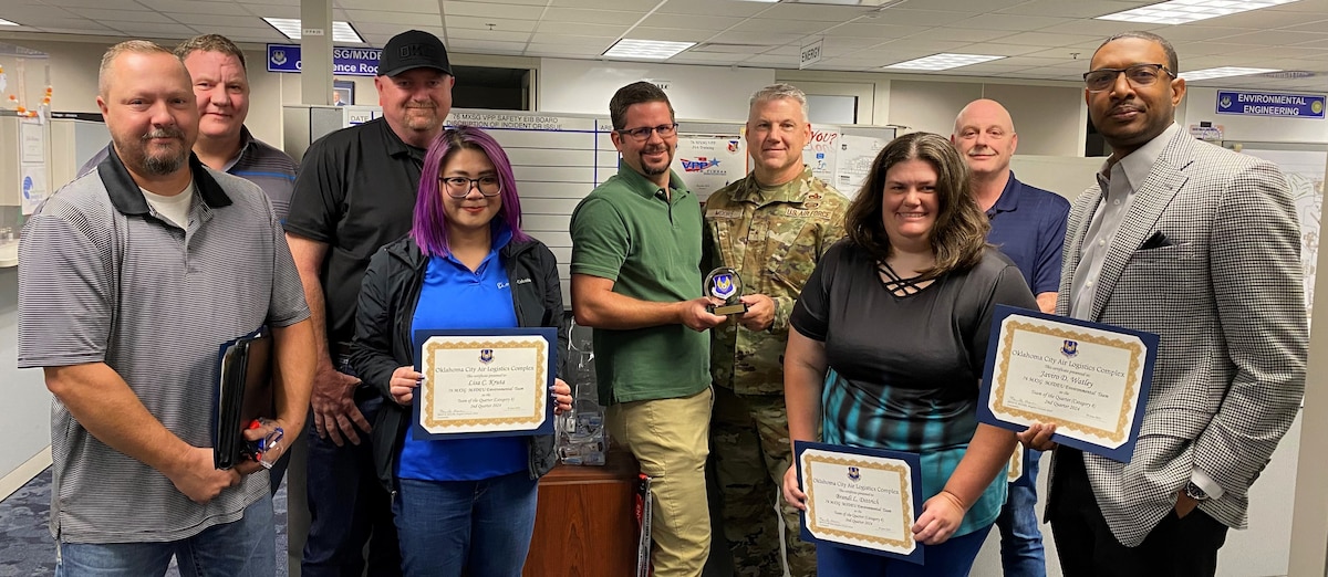 a group of men and two women holding certificates