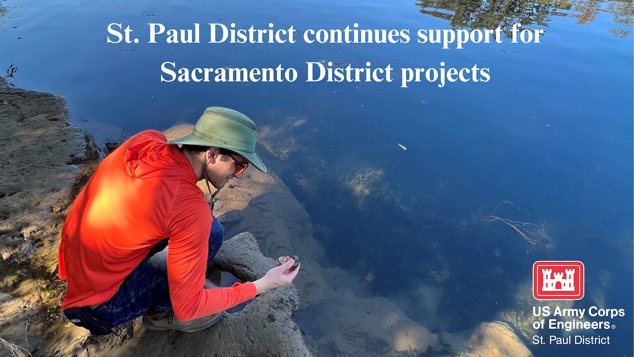 Courtesy photo of a man in Sacramento kneeling by a river picking up some soil. He is wearing a red/orange shirt and sun hat, Text reads "St. Paul District continues support for Sacramento District projects" and the St. Paul District logo is in the lower right corner.