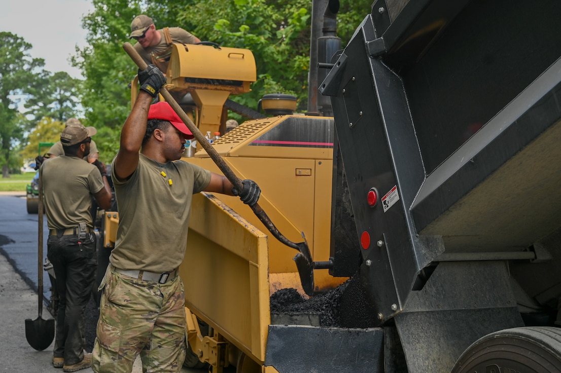 U.S. Airmen from the 633d Civil Engineer Squadron and the 203rd Rapid Engineer Deployable Heavy Operational Repair Squadron Engineers, work different positions on an asphalt paver to pave the entrance of Raptor Town at Joint Base Langley-Eustis, Virginia, Sept. 6, 2024. JBLE borrowed a paver from the 203rd RED HORSE Guardsman to improve base roads. (U.S. Air Force photo by Airman 1st Class Skylar Ellis)