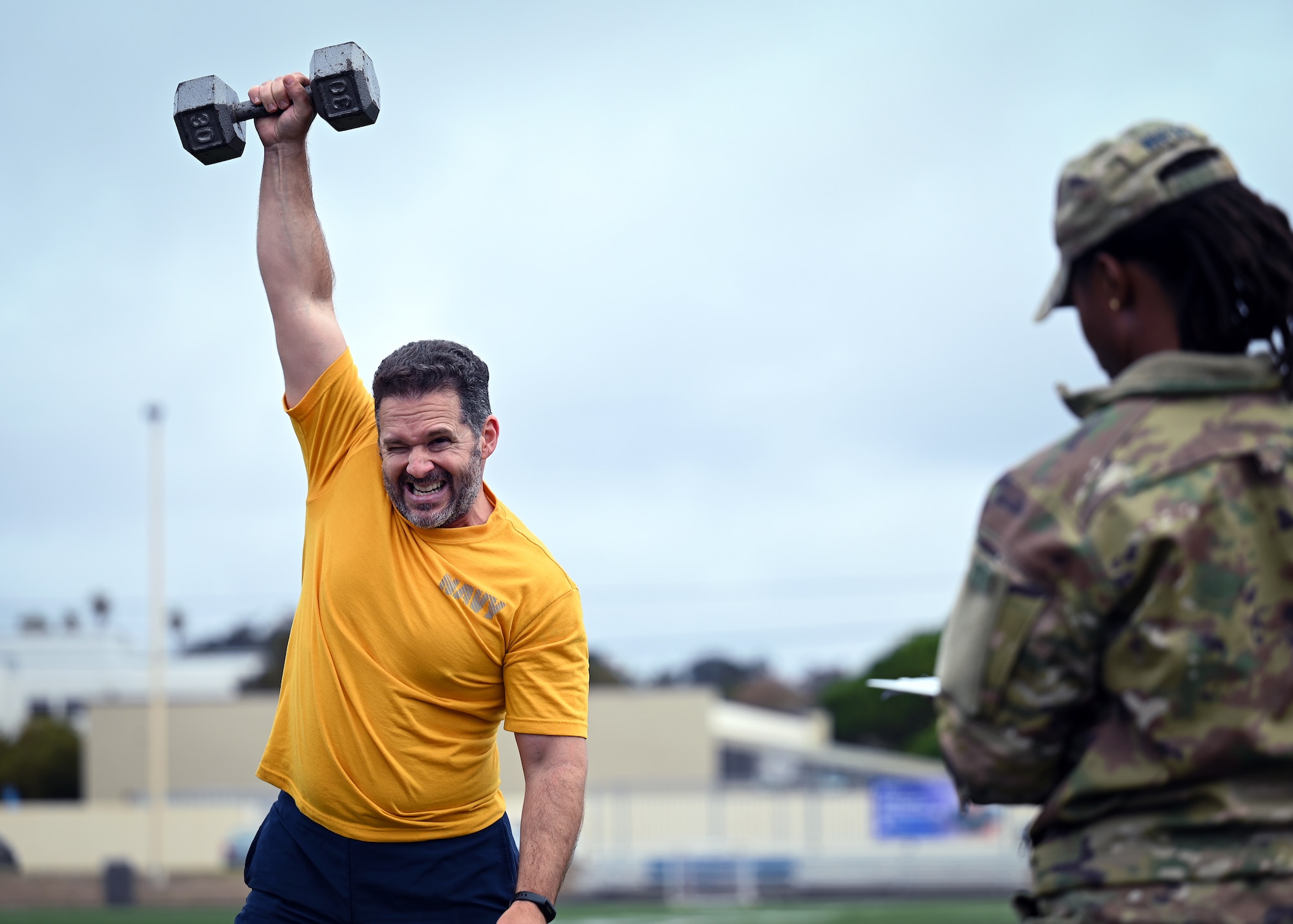 A man holding a dumbbell over his head.