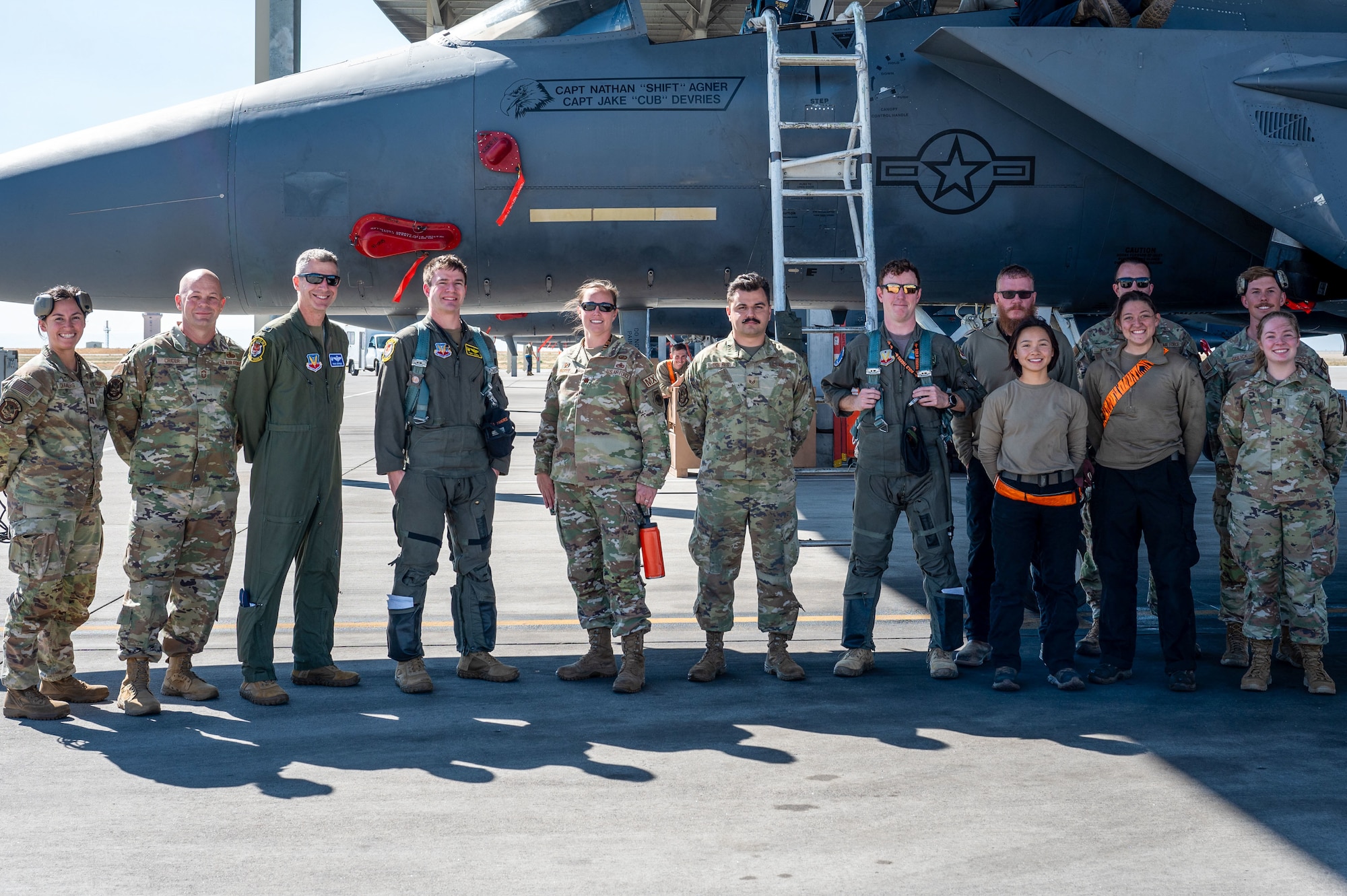 Airman pose in front of jet.