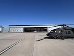 A Colorado Army National Guard UH-60 Black Hawk helicopter sits at the ready in front of a hanger at the Chief Warrant Officer 5 David R. Carter Army Aviation Support Facility located at Buckley Space Force Base, Aurora, Colorado, in September 2024. The newly constructed 21,600 square foot unheated aircraft storage hangar was built to allow for storage, inspection and sustainment of mission critical equipment that require protection from the harsh Colorado weather.  (U.S. Army National Guard photo)