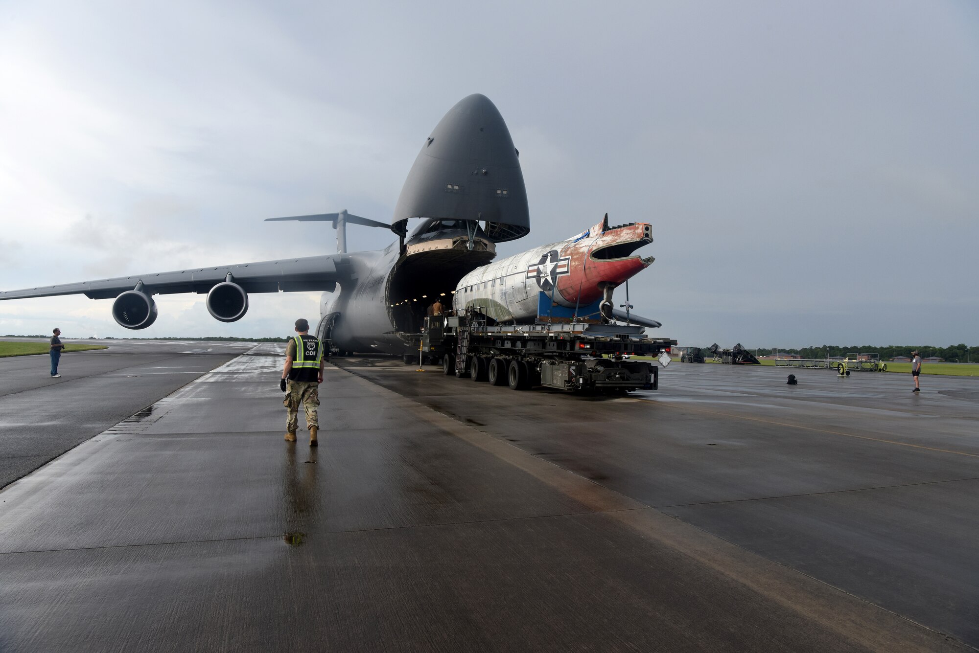 People unloading a smaller aircraft out of a large aircraft