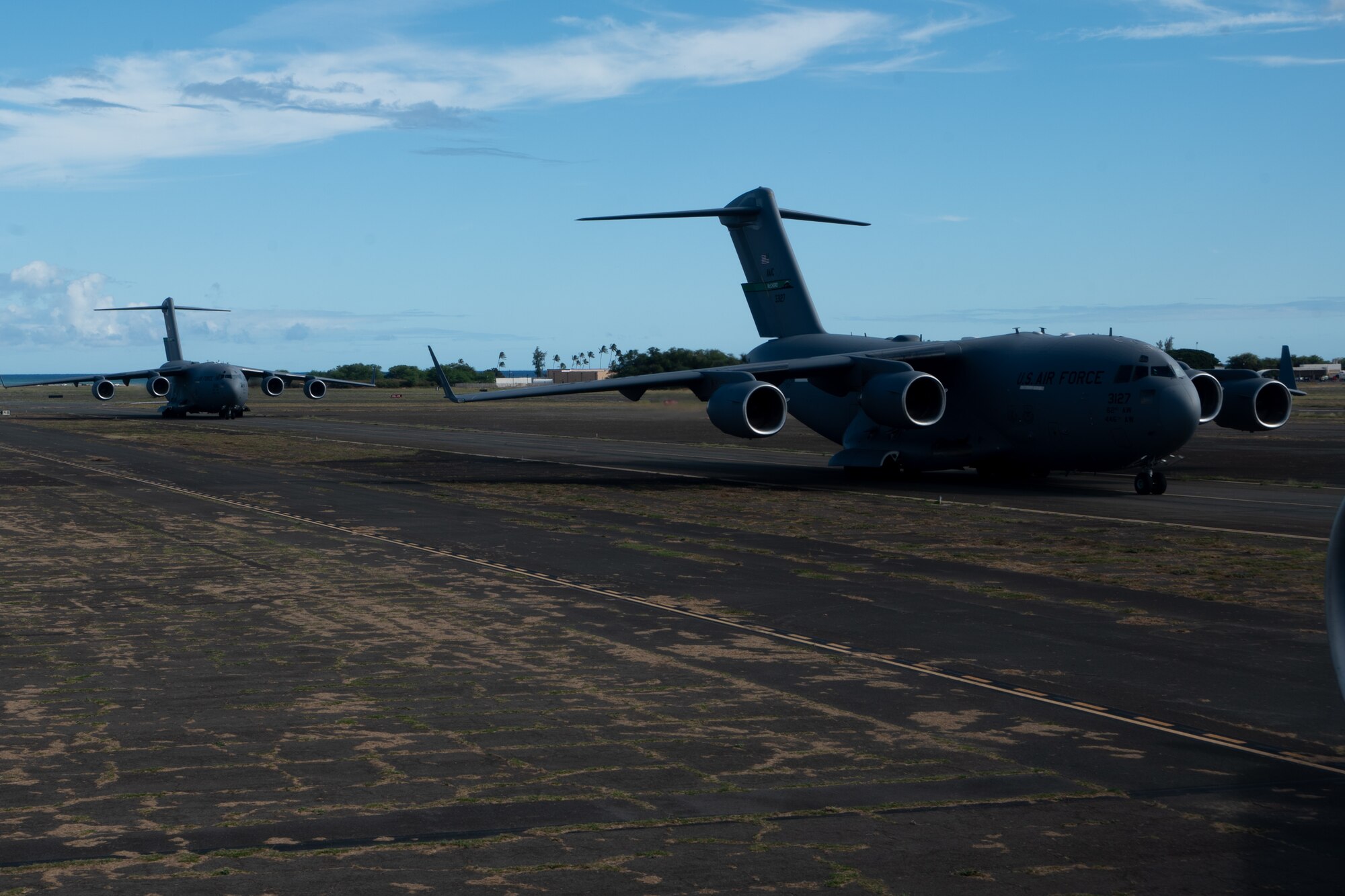 Two of the four C-17 Globemaster IIIs from the 7th Airlift Squadron taxi onto the Kalaeloa, Hawaii, flightline during a simulated deployment for Exercise Rainier War 25A on Oct. 4, 2024.