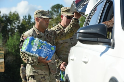 U.S. Army Staff Sgt. Kevin Garcia, a tank commander assigned to Bravo Company, 1-118th Infantry Regiment, Armored Brigade Combat Team, distributes water and supplies in Gaffney, South Carolina, Oct. 2, 2024.