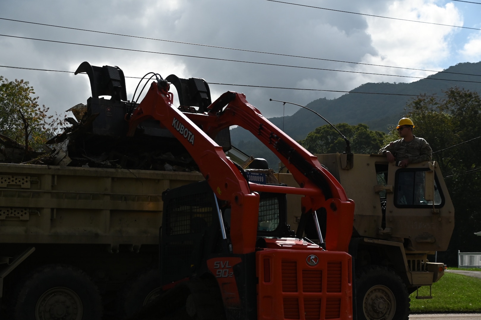 Tennessee Air National Guardsmen dropping debris into an Army truck in Hampton, Tennessee, on Oct. 2, 2024.