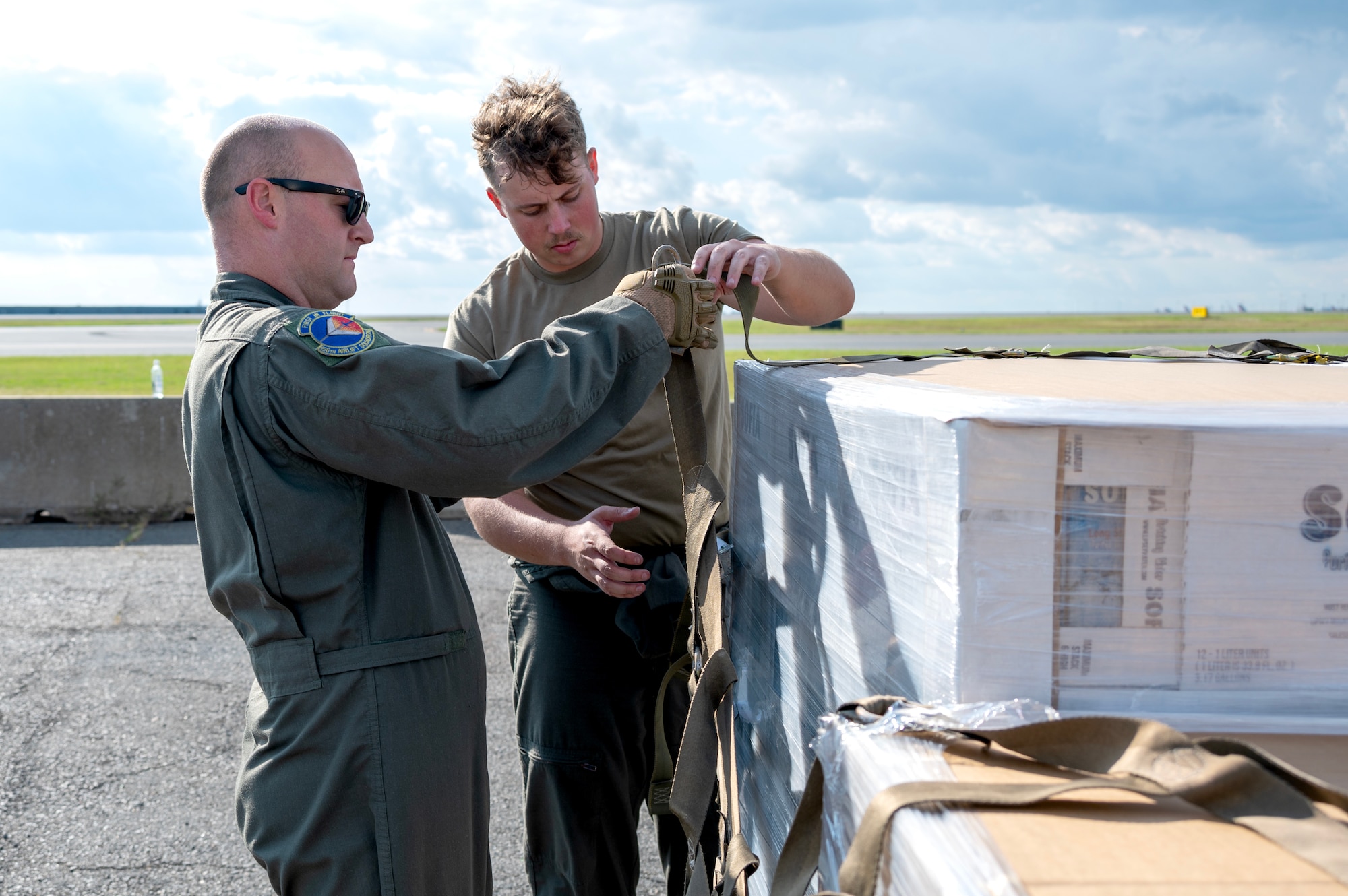 Tech. Sgt. Heath A. Houston, 156th Airlift Squadron loadmaster, left, and Airman 1st Class Eric S. Gumpert, 156th Airlift squadron loadmaster, right, palletize hurricane relief commodities for delivery to Western North Carolina in support of humanitarian efforts following Tropical Storm Helene at the North Carolina Air National Guard, Charlotte-Douglas International Airport, October 3, 2024. The pallets delivered aboard a C-17 Globemaster III consisted of Meals Ready to Eat (MREs), water, medication and other vital supplies (U.S. Air National Guard photo by Staff Sgt. Reanna Hartgrove)